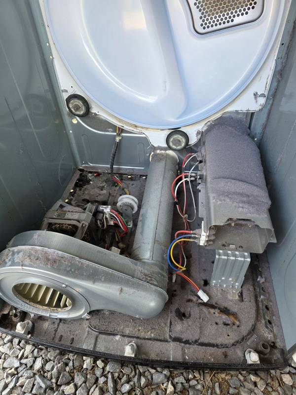 Dryer opened up for repair in Douglas, GA, showing the heater assembly, blower and lint buildup